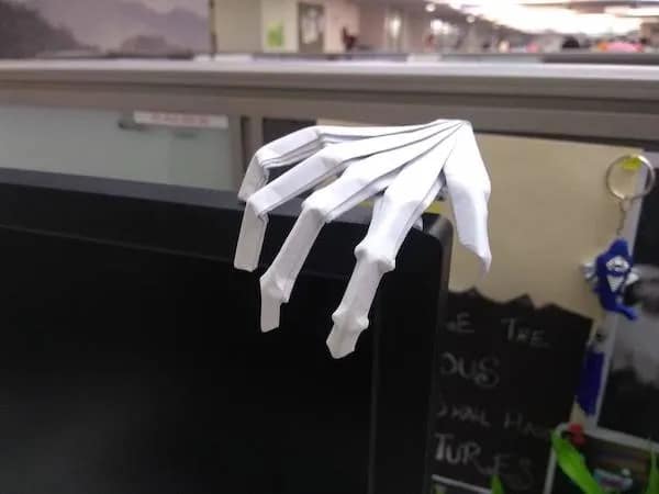 Origami skeleton hand resting on a computer monitor hilarious meme about waiting for emails.