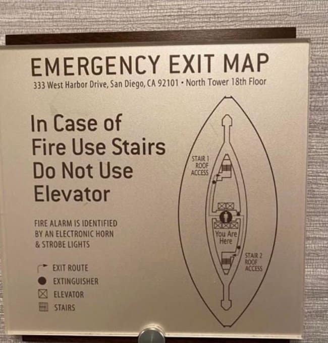 A hotel's emergency exit map displaying a major unfortunate design, as the oval layout of the building with its central hallway and stairwells creates a distinctly accidentally nsfw anatomical diagram.
