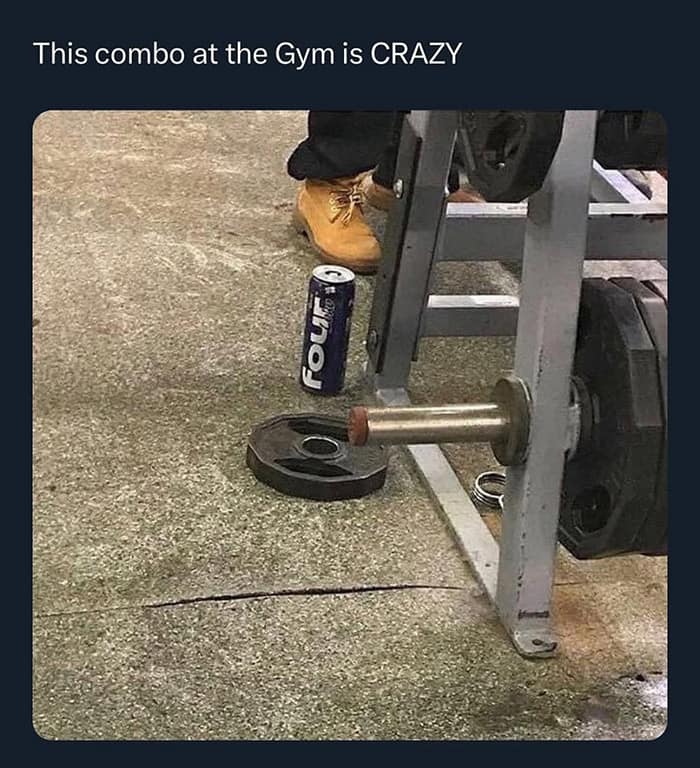 chaotic meme dump photo from a gym floor showing a truly unhinged pre-workout combo: a pair of tan work boots and a tall can of Four Loko sitting next to a weight rack.