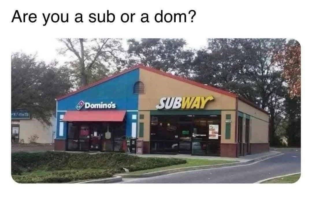 A funny photo of a shared building housing both a Domino's and a Subway restaurant.