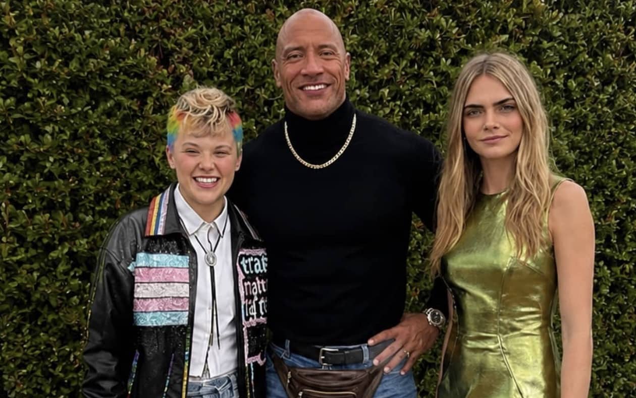 JoJo Siwa, Dwayne The Rock Johnson wearing a fanny pack, and Cara Delevingne posing together.