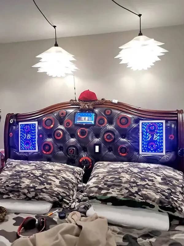 Custom leather headboard heavily modified with numerous built-in speakers and electronic devices in a bedroom.