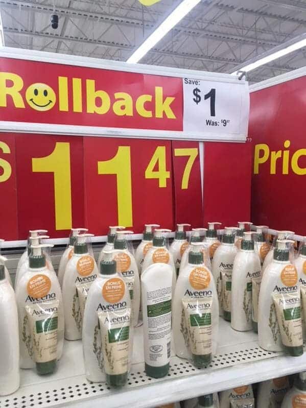 A retail math fail sign at a department store for Aveeno lotion. The "Rollback" sign claims a $1 savings from an original price of $9, but the large yellow price tag below lists the "new" price as $11.47.