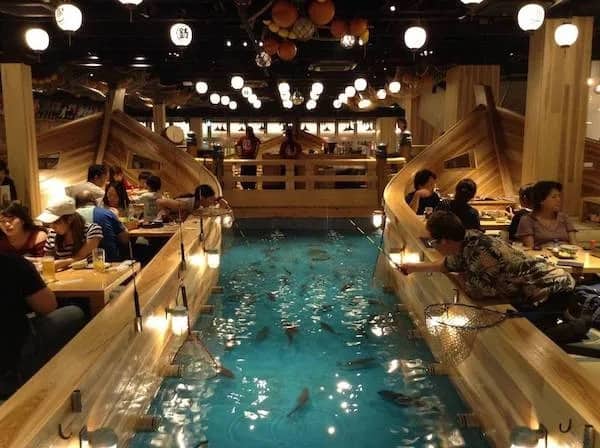 Unique Japanese restaurant where customers sit in wooden boats and fish for their dinner in an indoor pool.
