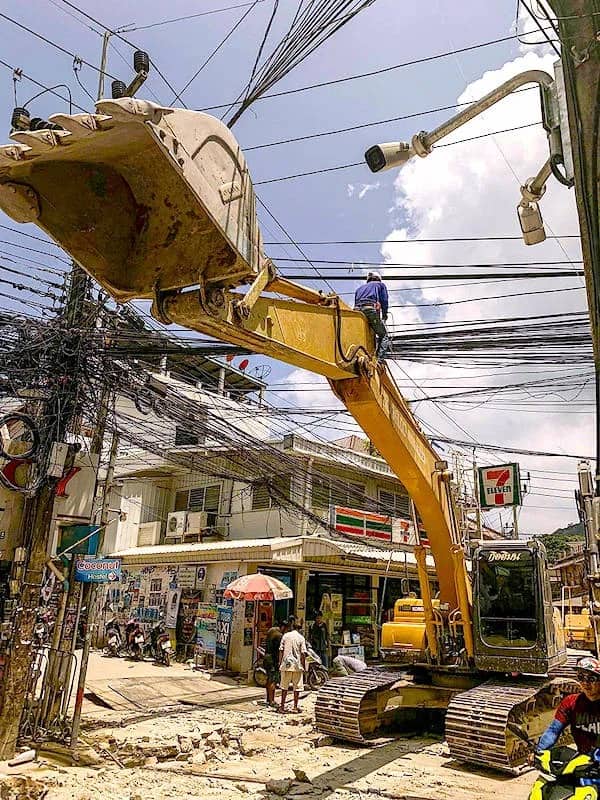 Terrifying image of an excavator arm entangled in a massive, messy web of power lines.