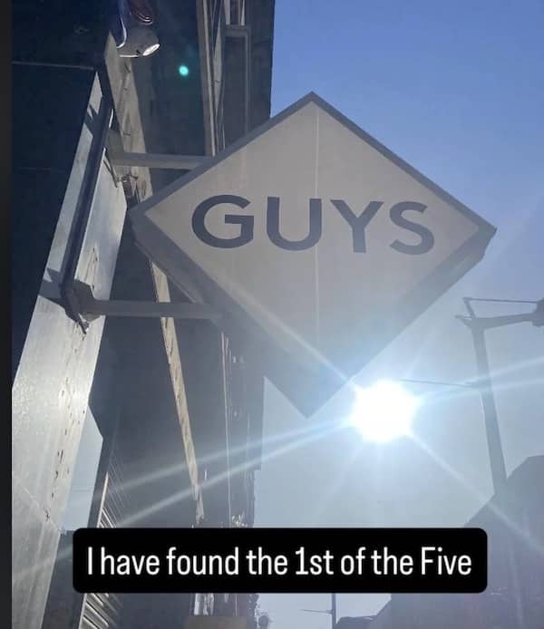Photo of a single "Guys" sign, jokingly captioned as finding the first of the "Five Guys."