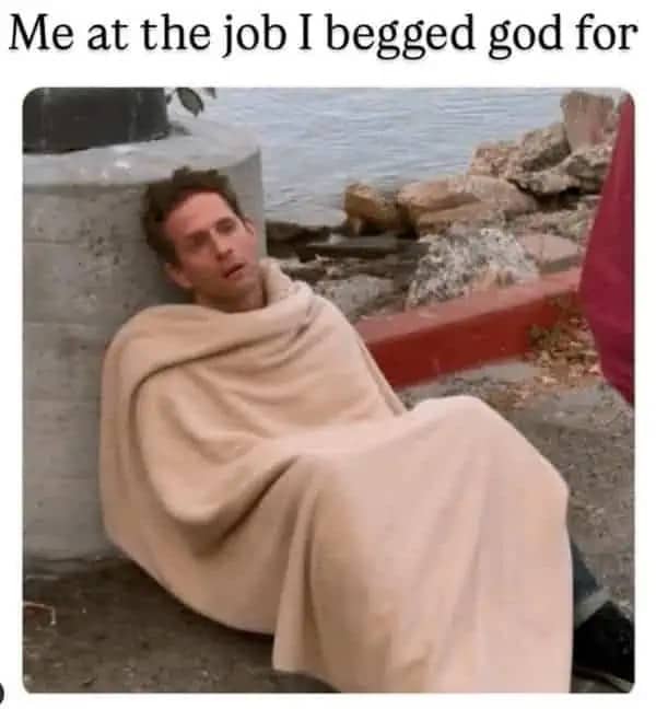 Dennis Reynolds from It's Always Sunny in Philadelphia slumped against a concrete pillar looking exhausted under a blanket.