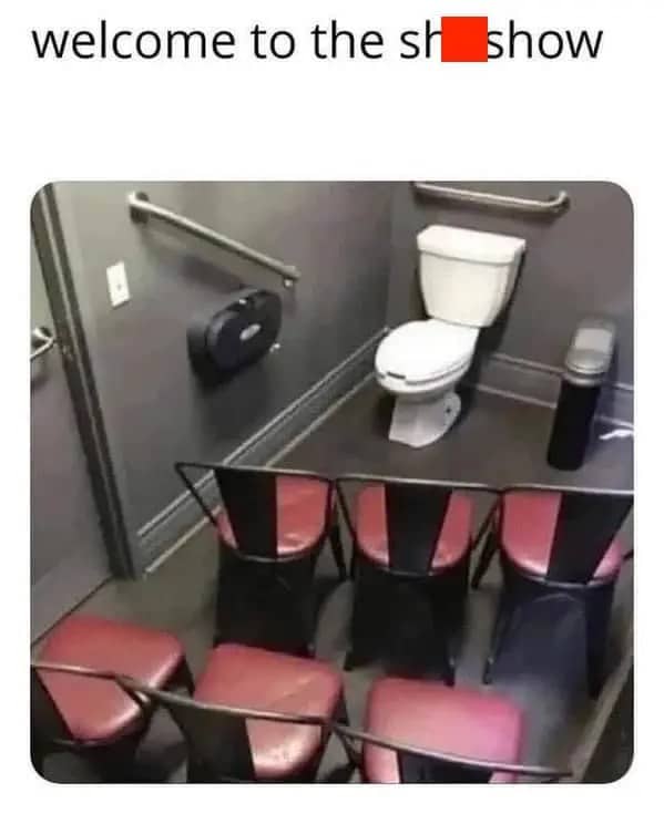 A photo of a bathroom stall with several rows of chairs facing the toilet.