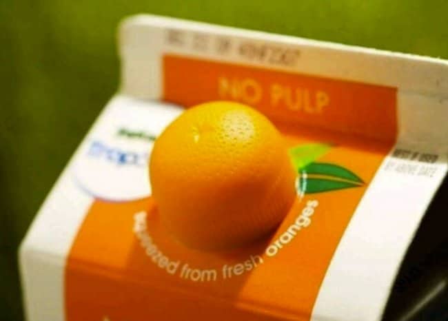 Close up view of an orange juice carton featuring a creative dome shaped plastic cap styled like a real orange.
