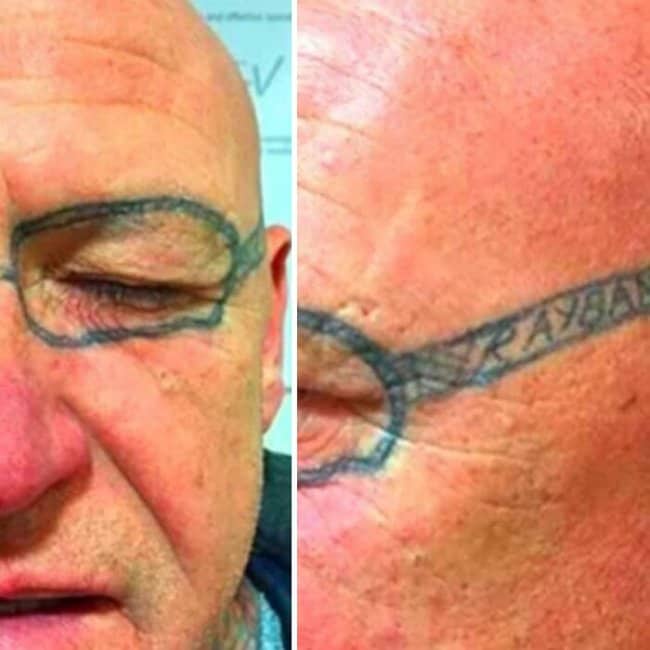 Extreme close-up of a man's face with permanent thick black Ray-Ban glasses tattooed on his temples.
