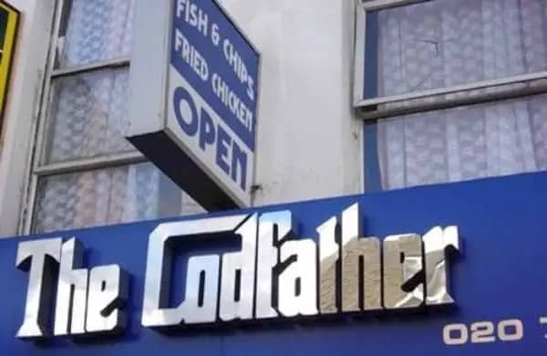 A storefront sign for a fish and chips restaurant clever jokes business name called The Codfather.