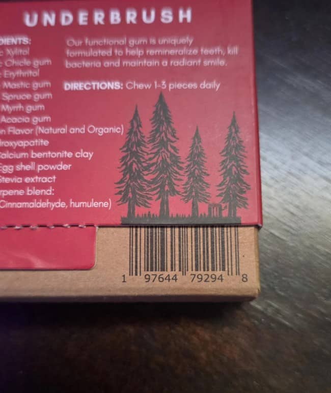 A creative barcode topped with a silhouette of tall pine trees on a red box.