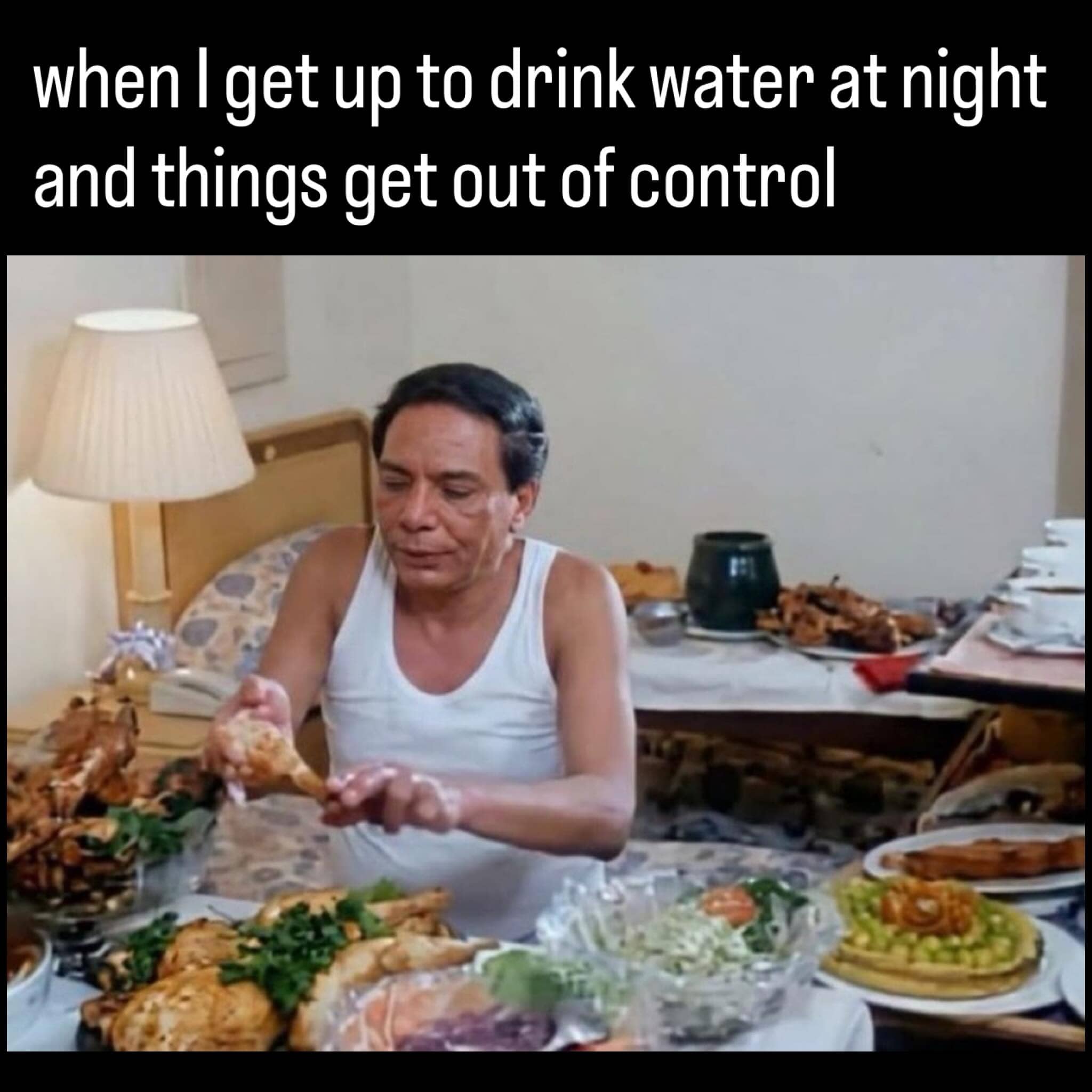 Late night kitchen meme showing a man in a tank top surrounded by an overwhelming feast.
