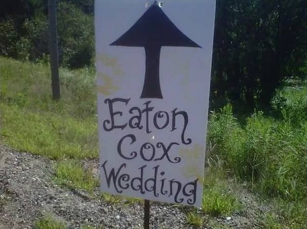 Humorous outdoor wedding directional sign displaying the unfortunate combination of the couples last names.