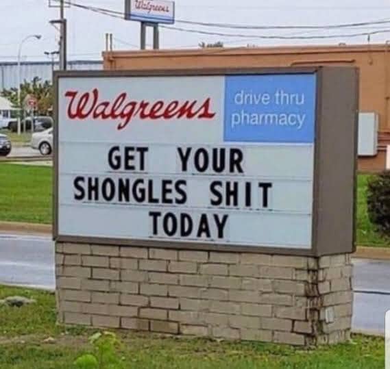 Funny Walgreens street marquee sign typo reading get your shongles shit today on brick base.