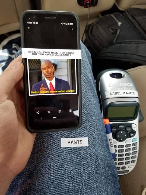 A smartphone with a physical label maker sticker attached to mock a meme layout.