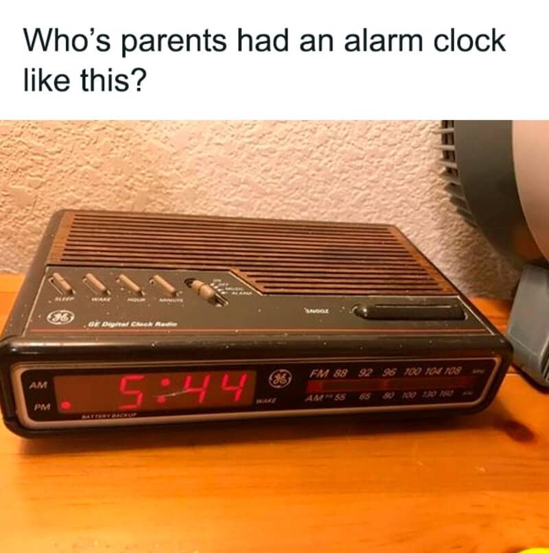 Vintage woodgrain General Electric digital clock radio displaying the time five forty-four in red.