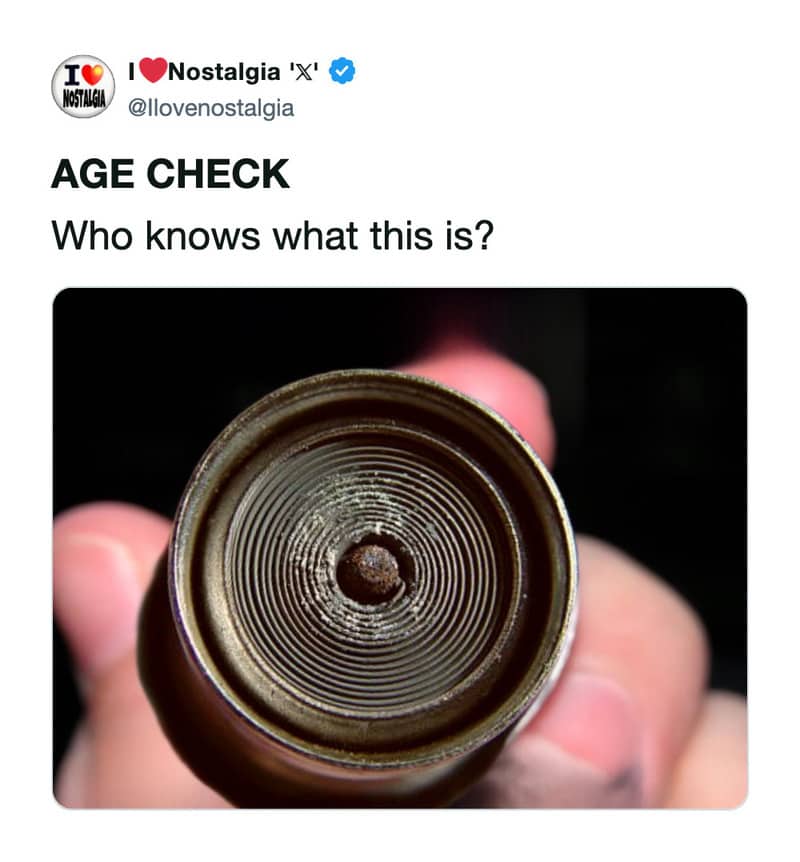 A metal automotive cigarette lighter element glowing faintly orange inside a dark interior background.
