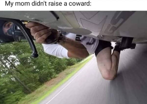 First person point of view of a person leaning wildly off a fast motorcycle on a highway.