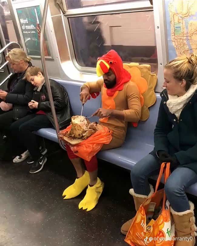 Man in a turkey costume carving a roasted turkey on his lap for funny public transit memes.