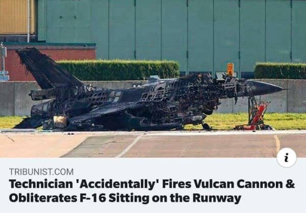 A completely destroyed and burnt F-16 fighter jet sitting on a military airport runway.