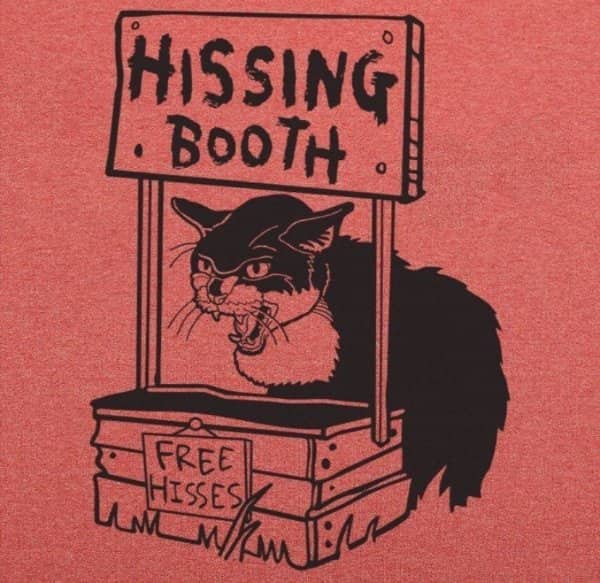 Linocut style art of a grumpy black cat in a wooden booth labeled hissing booth free hisses.