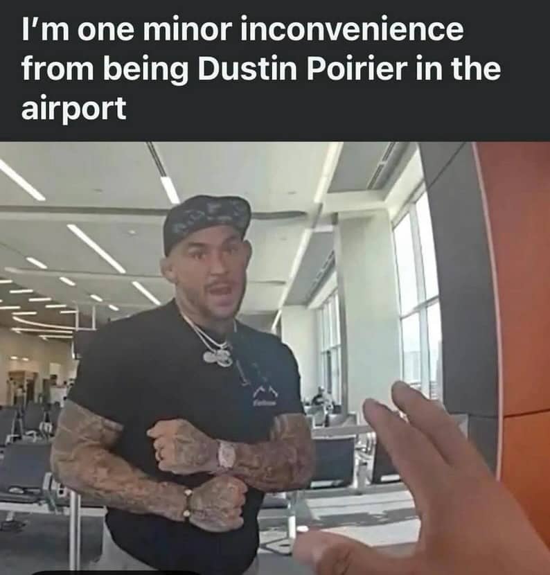 First person perspective showing a hand reaching toward an irritated Dustin Poirier standing inside an airport.
