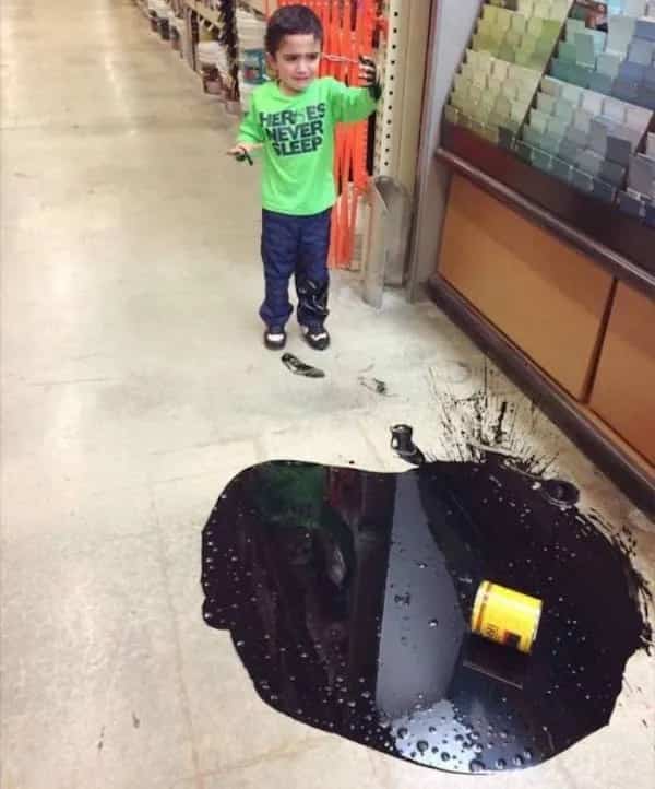 Funny memes scene of a crying toddler who spilled a can of dark black paint.