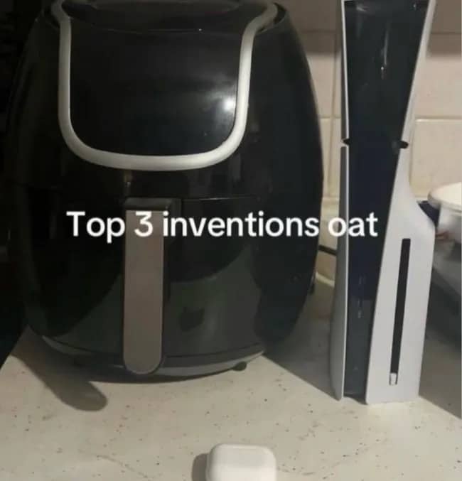 Photograph showing an air fryer, a PlayStation 5 console, and wireless earbuds on a counter.