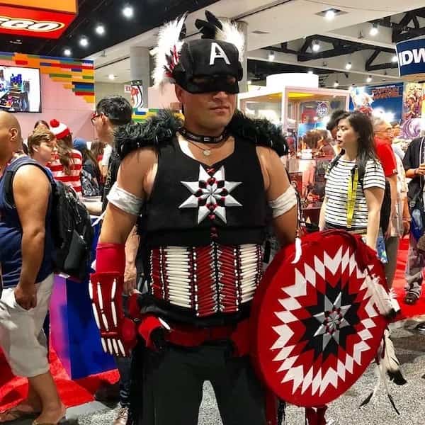 Impressive Native American Captain America cosplay costume with traditional patterned shield at comic convention.