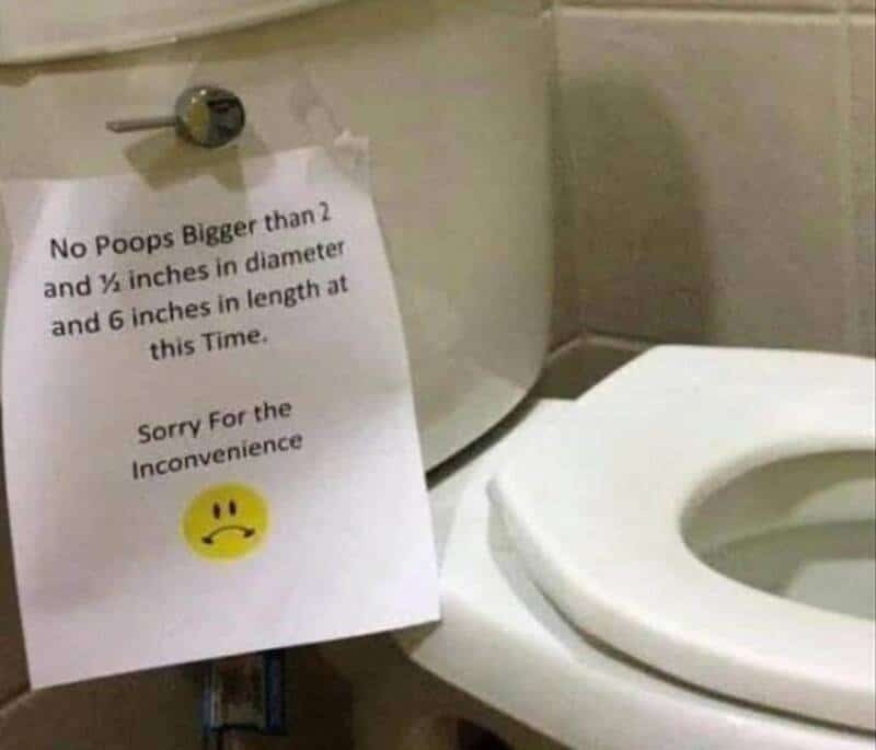Funny bathroom toilet sign requesting specific maximum poop size restrictions with sad face emoji.