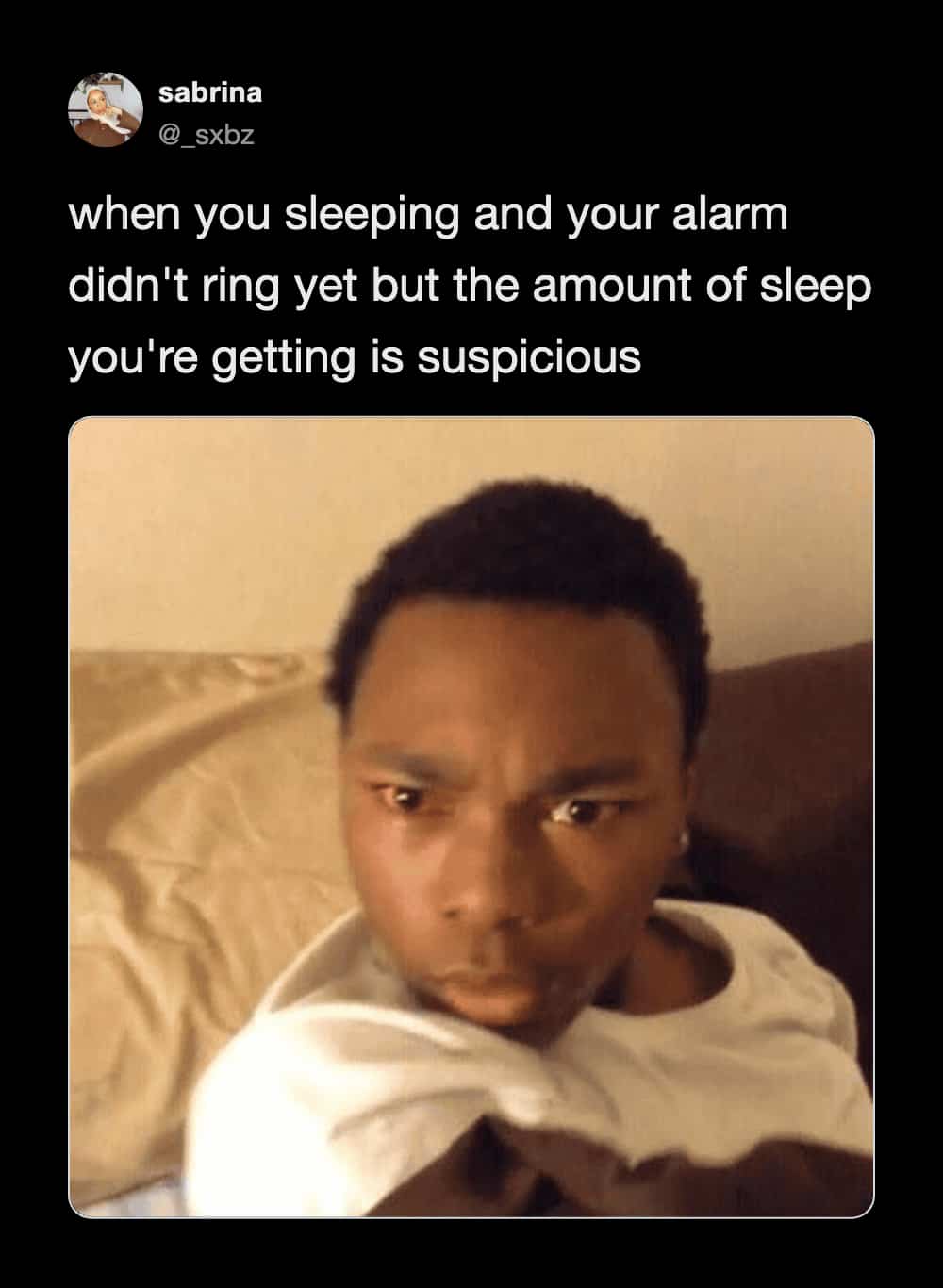 Wide-eyed man staring suspiciously in bed before his alarm rings in a funny sleep meme.