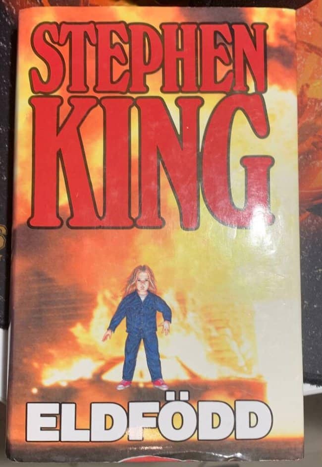Stephen King novel cover titled Eldfödd featuring a small child standing before massive flames.