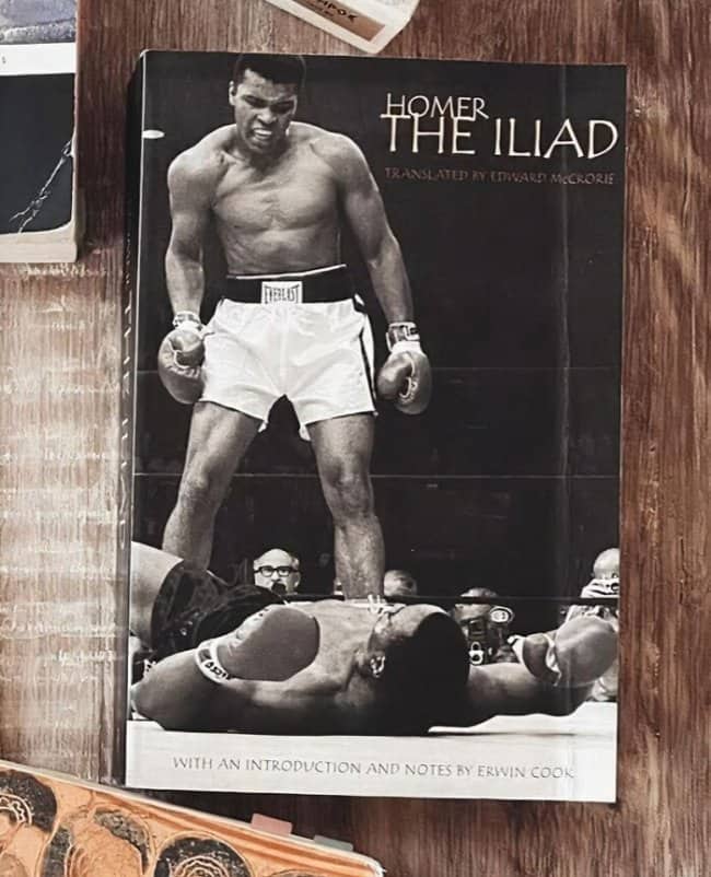 Edition of The Iliad featuring a classic Muhammad Ali boxing photo on cover.