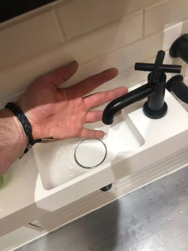 An impossibly small sink basin with a faucet that leaves no space for washing hands.