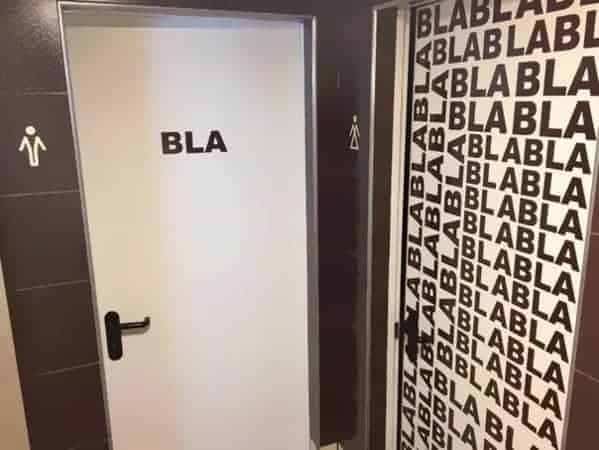 Gender restroom doors featuring sexist signage labeled BLA for men and repetitive BLABLA for women.