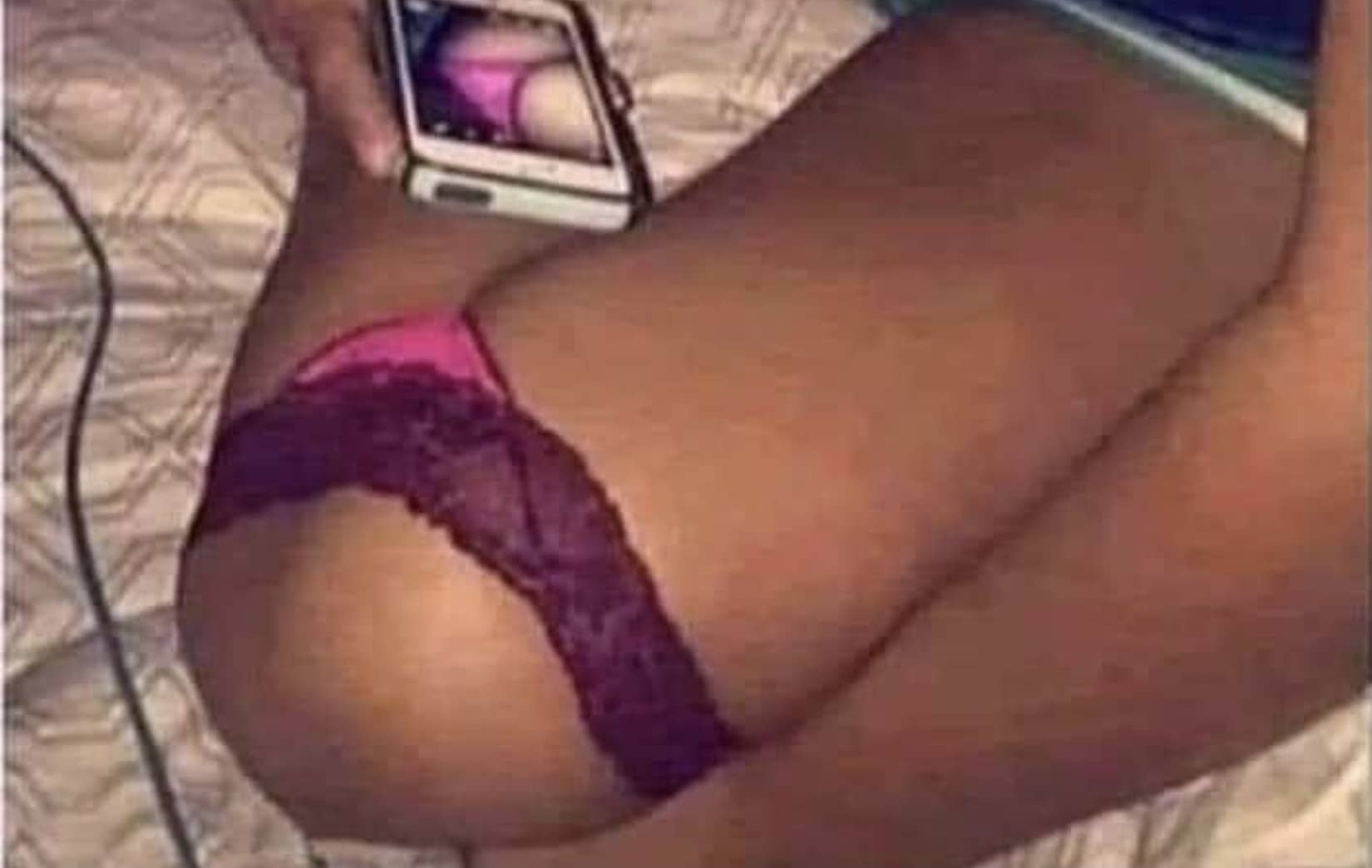 Optical illusion showing bent knees dressed in pink lace underwear pretending to look like an explicit photo.