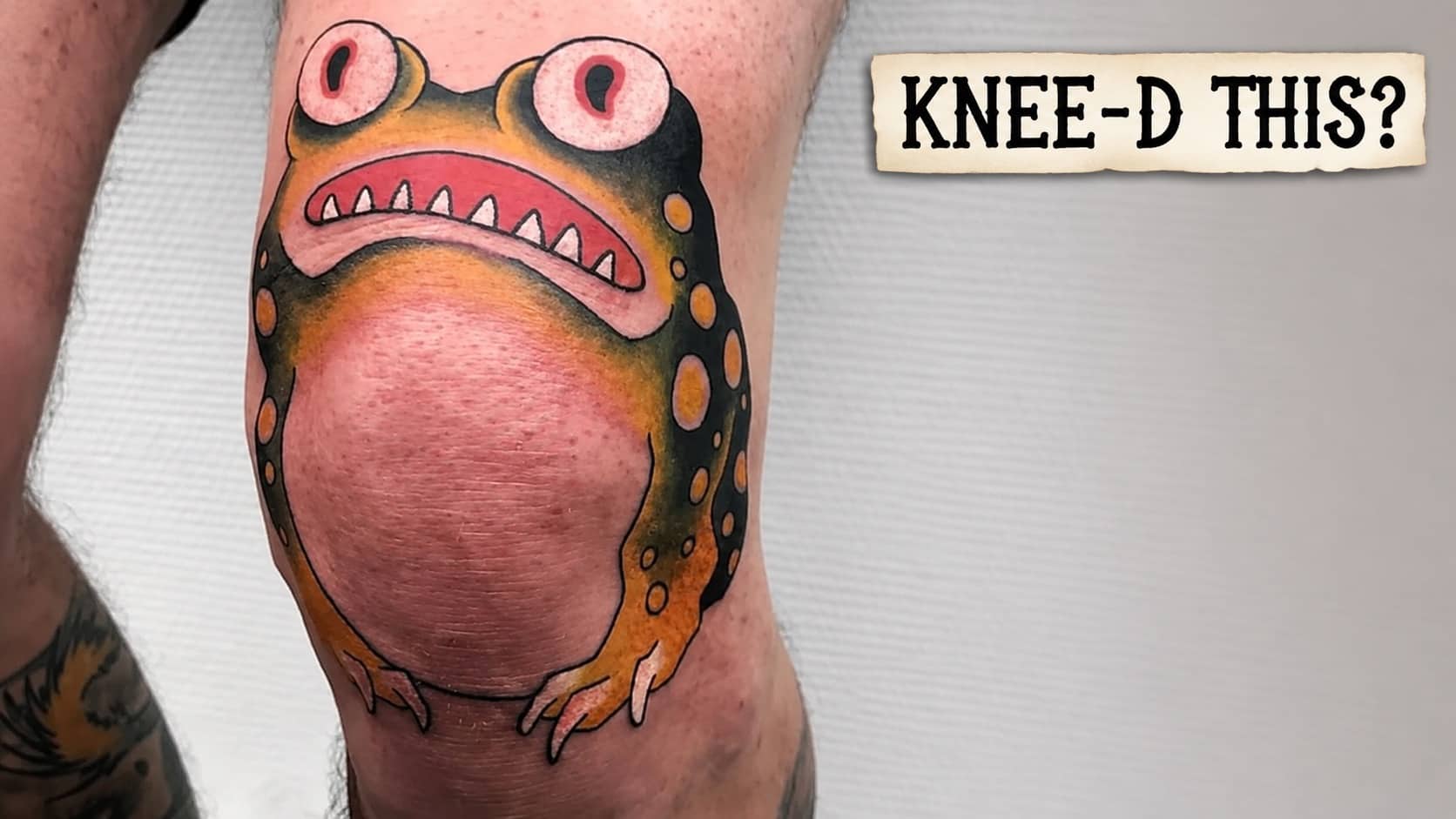 Funny tattoos design featuring a wide-eyed cartoon frog inked directly onto a person's knee.