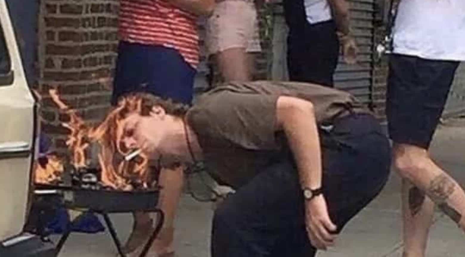Funny meme of a man leaning close to light a cigarette directly off grill flames.