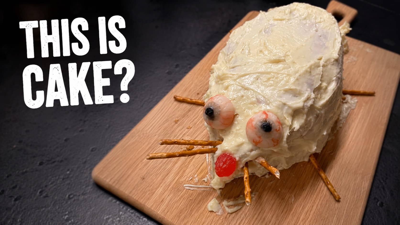 Funny mouse cake made with white icing, pretzel stick whiskers, and candy eyes.