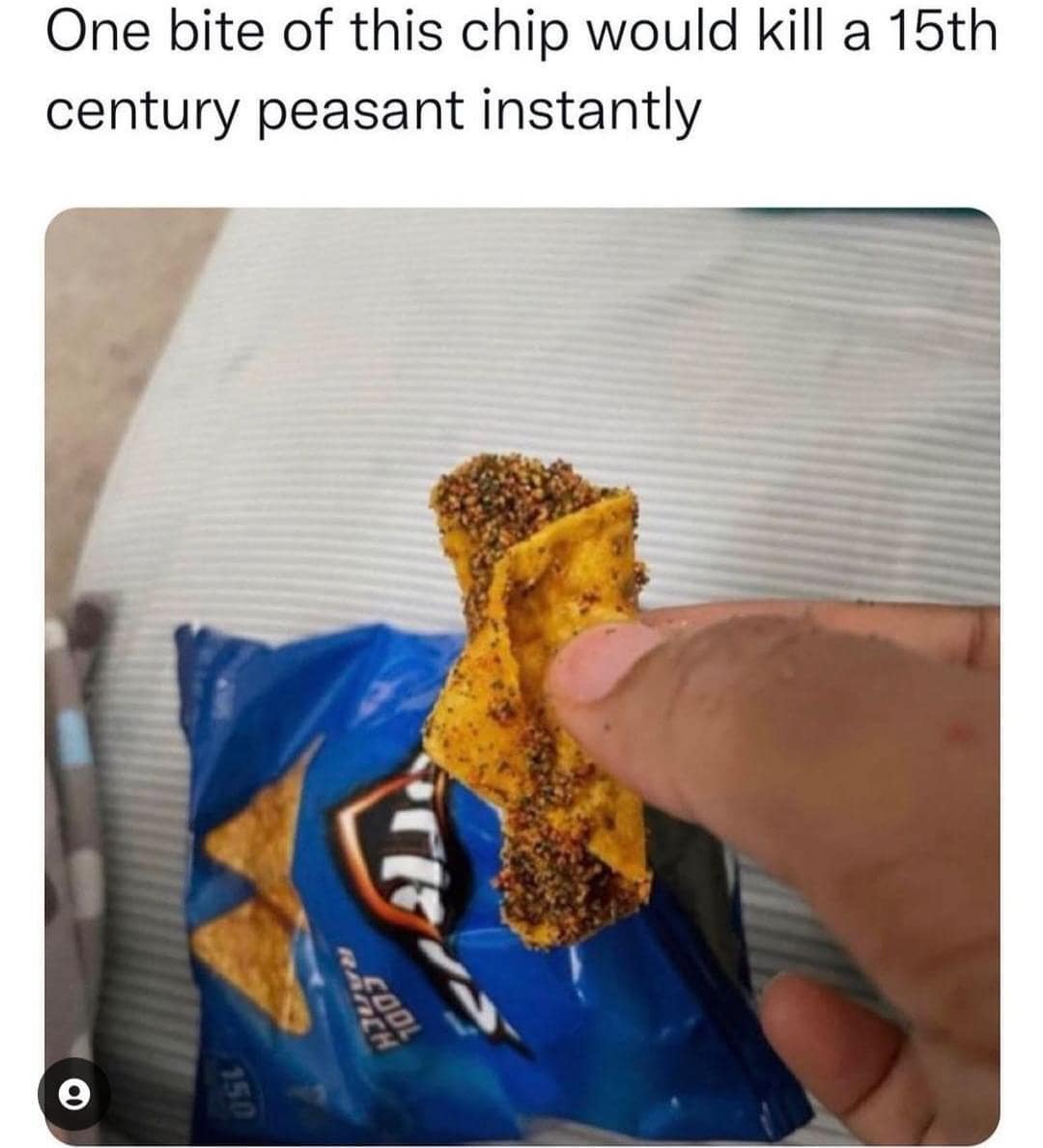 Close-up photo of a Cool Ranch Dorito chip completely coated in a thick, dark layer of seasoning powder, captioned that a single bite would kill a medieval peasant.