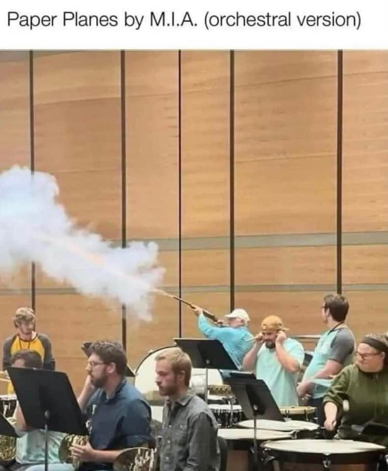 A hilarious musical performance edit used in this classic meme set, showing a percussionist firing an actual shotgun indoors to replicate the gunshots in M.I.A.'s "Paper Planes" for an orchestral concert.