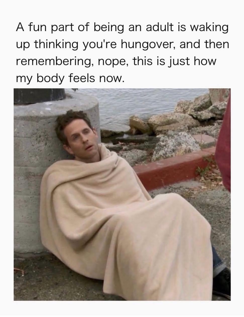 An adult physical baseline classic meme featuring Dennis Reynolds wrapped in a blanket on a curb, realizing morning aches aren't a hangover but just daily life.