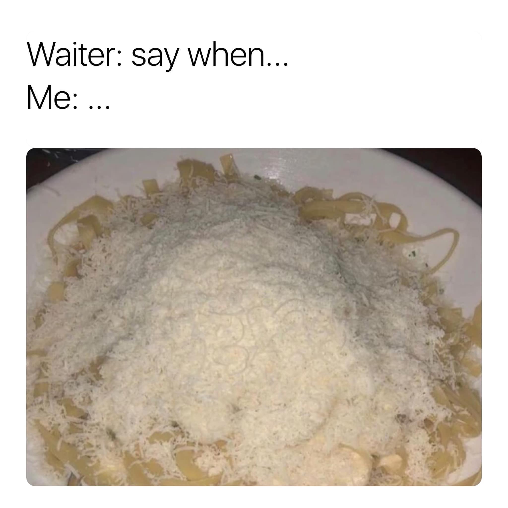 A bowl of fettuccine pasta buried beneath an absurd, overflowing mountain of freshly grated parmesan cheese, formatted as a classic meme.