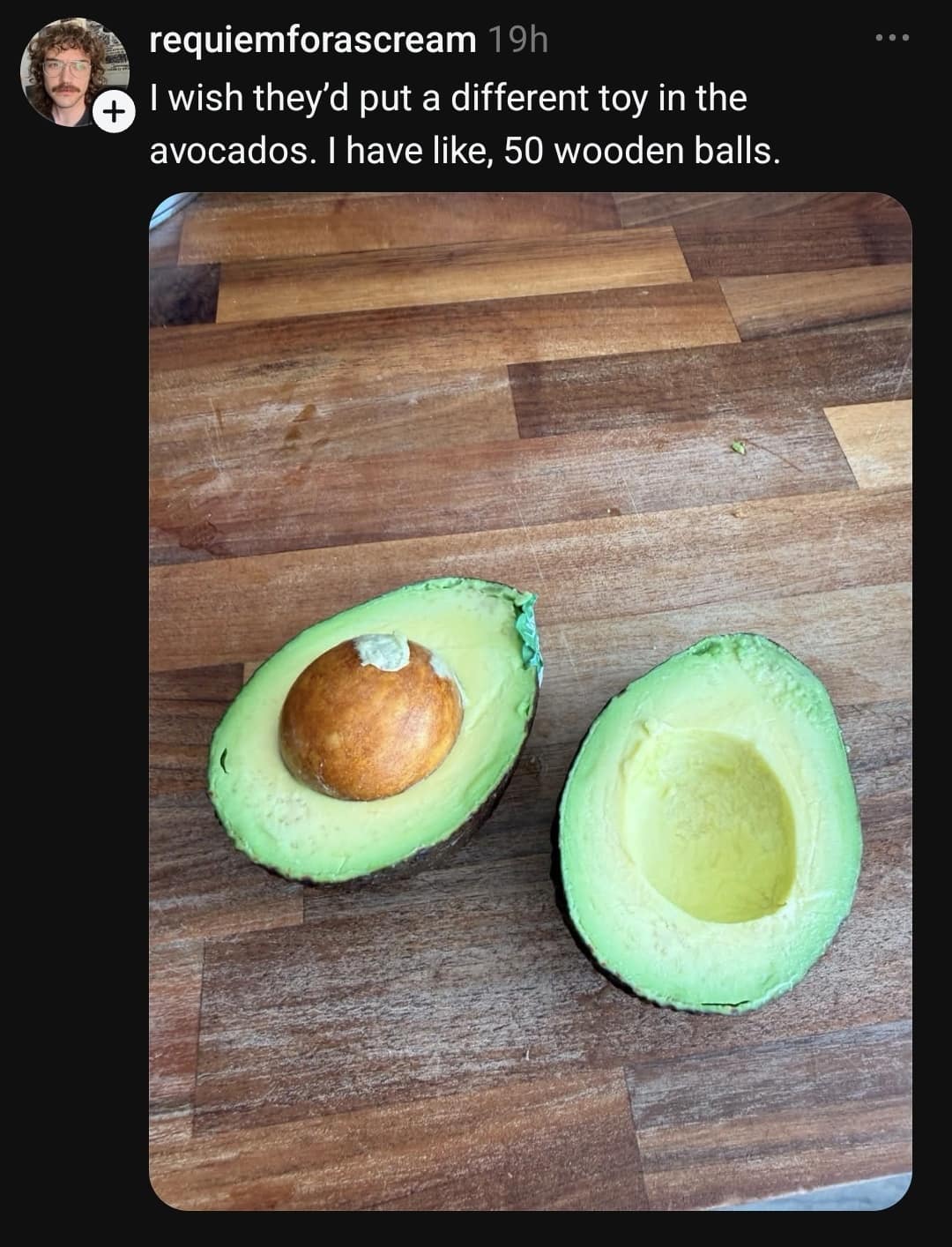 Photo of a sliced avocado on a cutting board, paired with a funny caption complaining about collecting 50 wooden ball toys inside avocados.