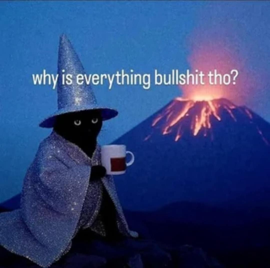 An existential black cat wearing a sparkly wizard hat and cape while holding a mug in front of an erupting volcano in a classic meme, captioned "why is everything bullshit tho?".