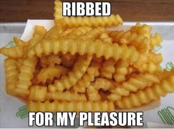 Image macro of a mound of golden crinkle-cut French fries captioned with the iconic double-entendre line "RIBBED FOR MY PLEASURE" as a classic meme.