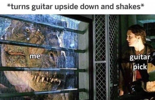Movie screenshot from The Lost World: Jurassic Park featuring a T-Rex staring through a glass window, labeled as a guitarist trying to shake out a lost pick inside an acoustic guitar.