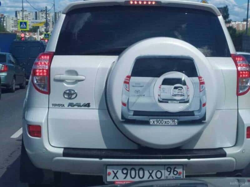 White Toyota RAV4 spare tire cover printed with recursive picture of itself funny memes.