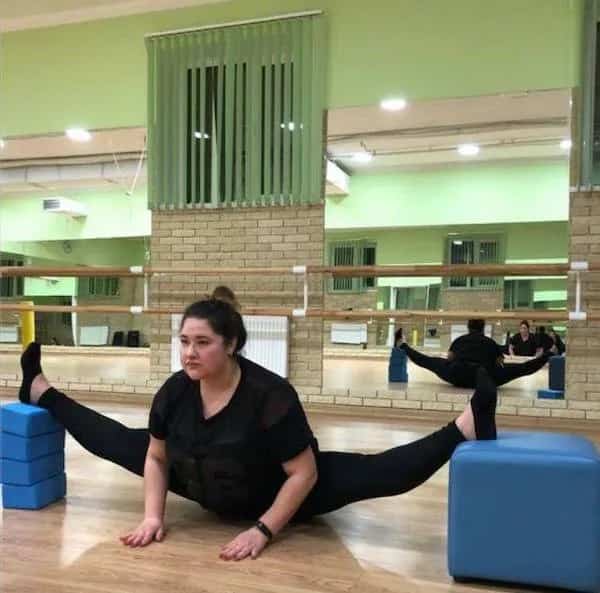 Flexible woman executing wide side split using yoga blocks during training funny memes.
